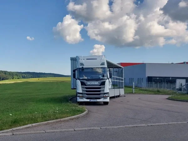 Zestaw WAAN Transport z otwartą naczepą kurtynową przy zakładzie produkcyjnym