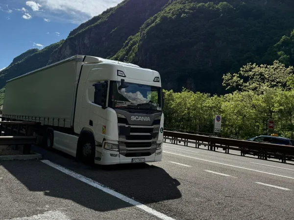 Ciągnik WAAN Transport z naczepą kurtynową na trasie w górach